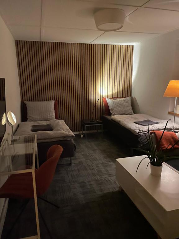 Cette chambre comprend deux lits, une table et un canapé. dans l'établissement Helts B&B - Helts Guesthouse, à Herning