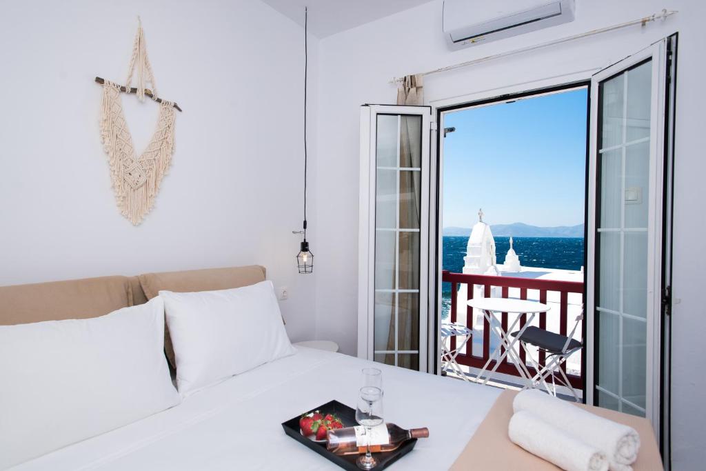 - une chambre avec un lit et une vue sur l'océan dans l'établissement Myconian Little Venice Elite Suites with Sea View, à Mykonos