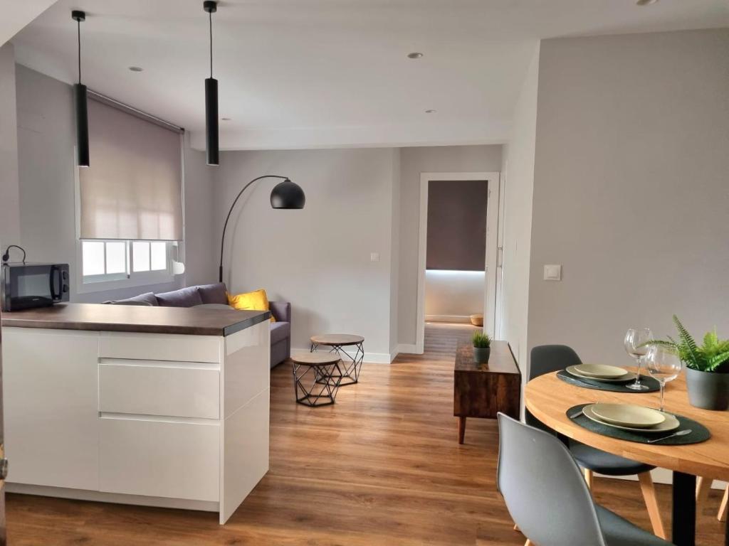 een keuken en woonkamer met een tafel en stoelen bij Aujada playa in Cádiz