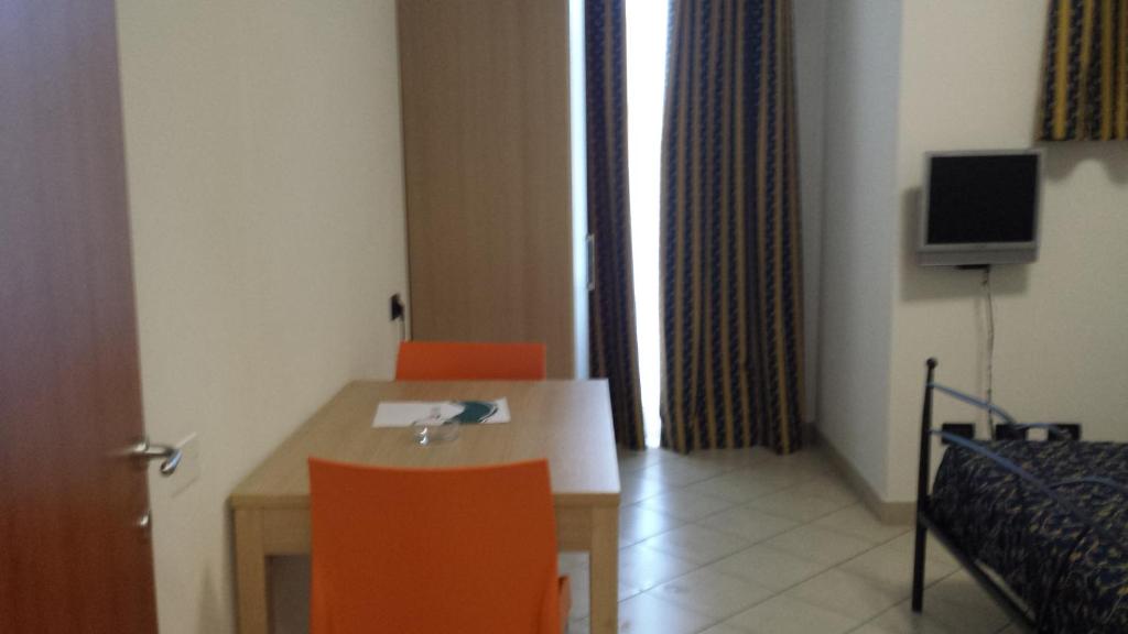 una stanza con un tavolo e due sedie arancioni di Hotel Residence Le Terrazze a Portovenere