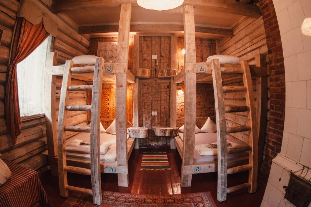 a room with two bunk beds in a log cabin at Sunny Nights Homestead Historic House in Gataučiai
