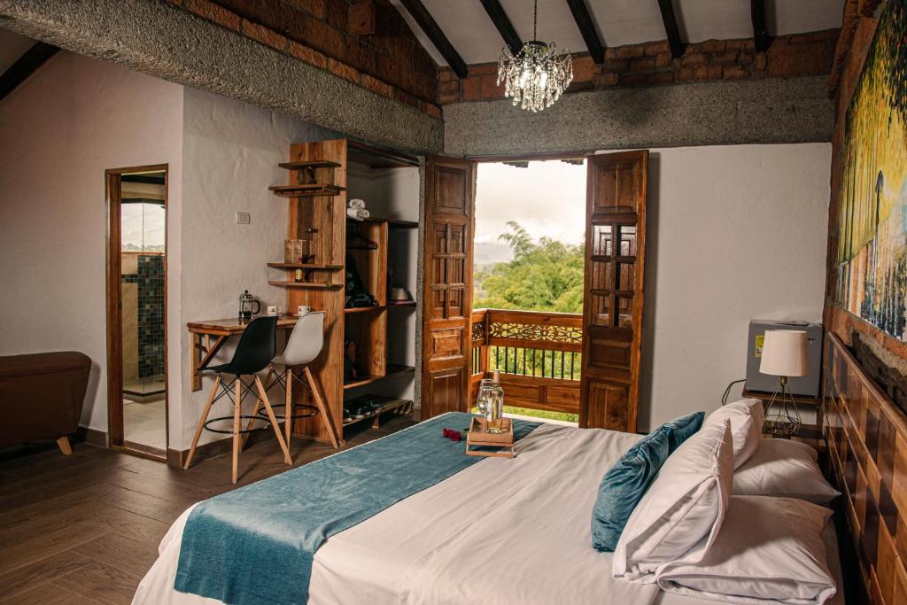 a bedroom with a bed and a desk and a window at Hotel Santa Laura in Jericó