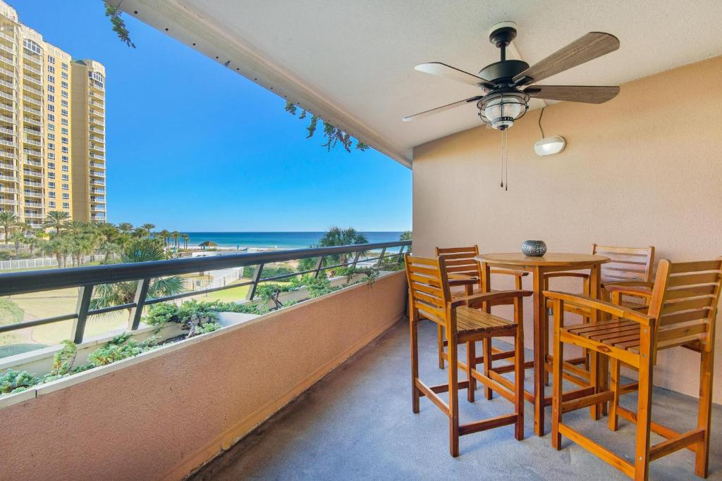 a balcony with a table and chairs and a view of the ocean at Edgewater #308 in Destin