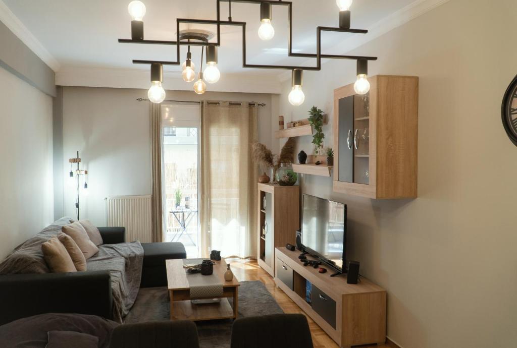 a living room with a couch and a television at Theo Apartments in Thessaloniki