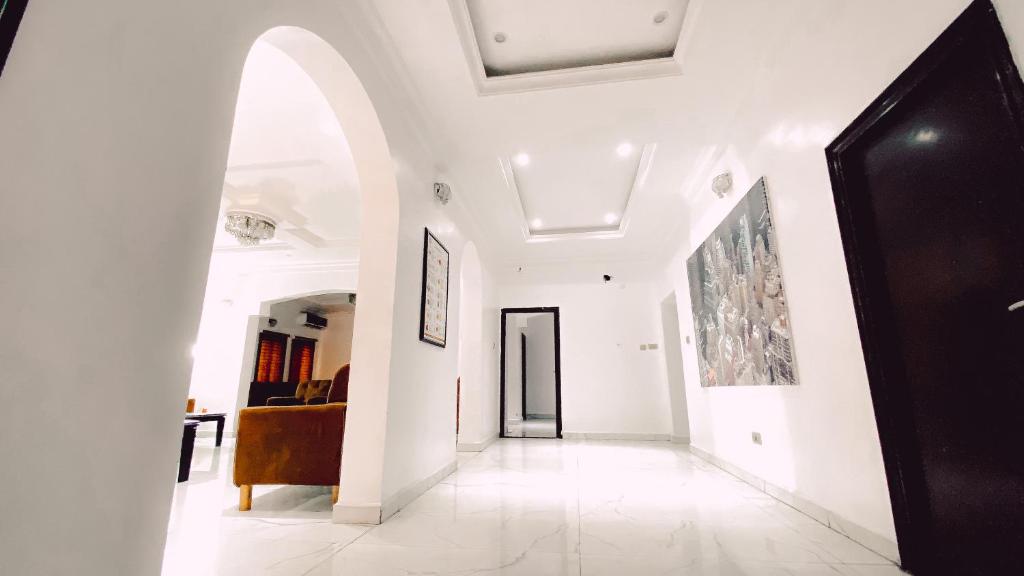 un pasillo con paredes blancas y una puerta arqueada en Royal Court Lounge & Boutique Hotel, en Port Harcourt