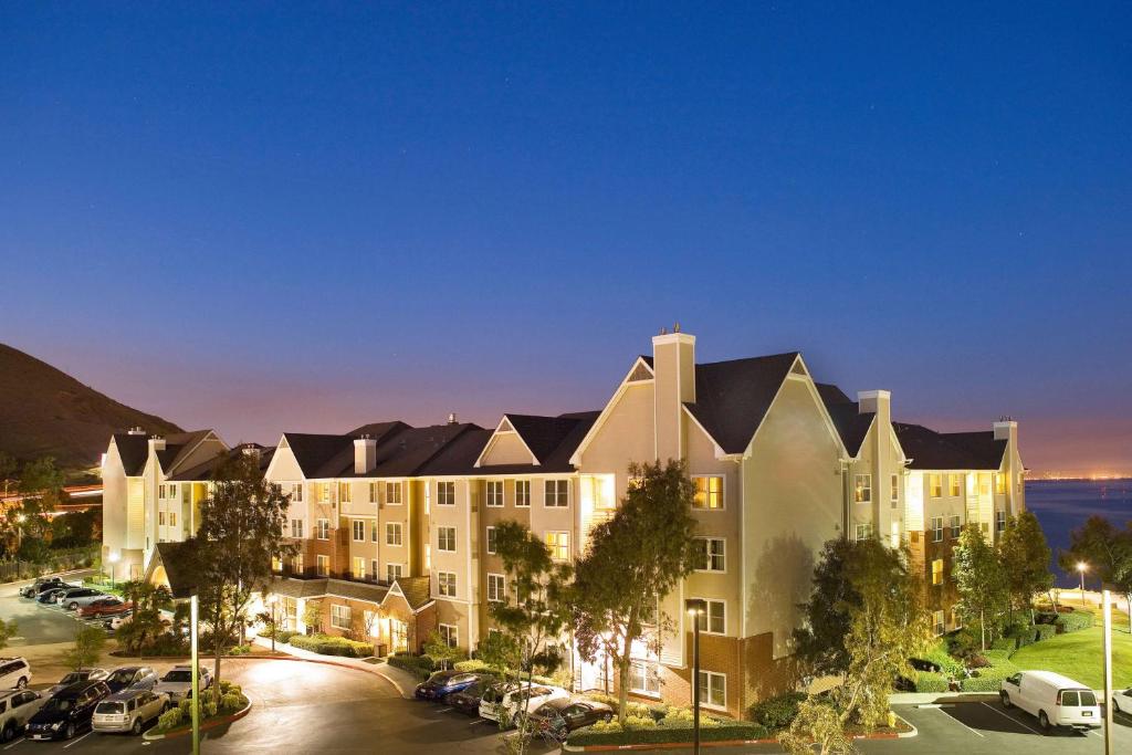 a large building with cars parked in a parking lot at Sonesta ES Suites San Francisco Airport Oyster Point Waterfront in South San Francisco