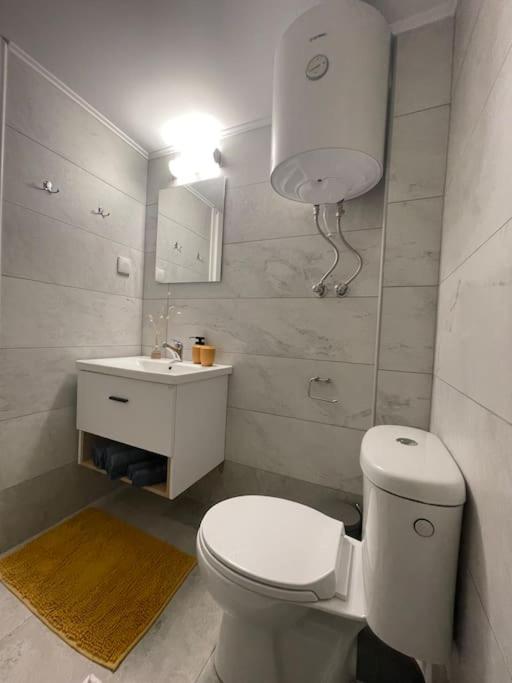 a white bathroom with a toilet and a sink at Vatos Studio in Vátos