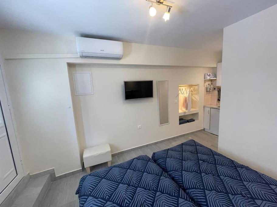 a bedroom with a bed and a tv on the wall at Vatos Studio in Vátos