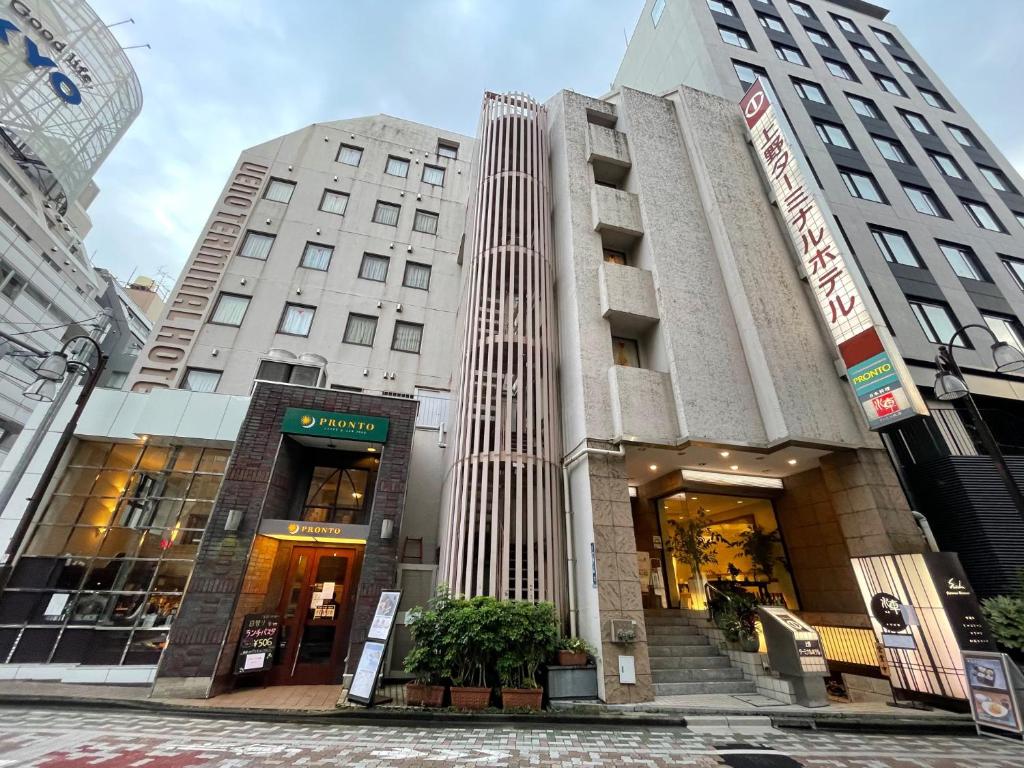 un edificio en una calle con dos edificios altos en Ueno Terminal Hotel, en Tokio