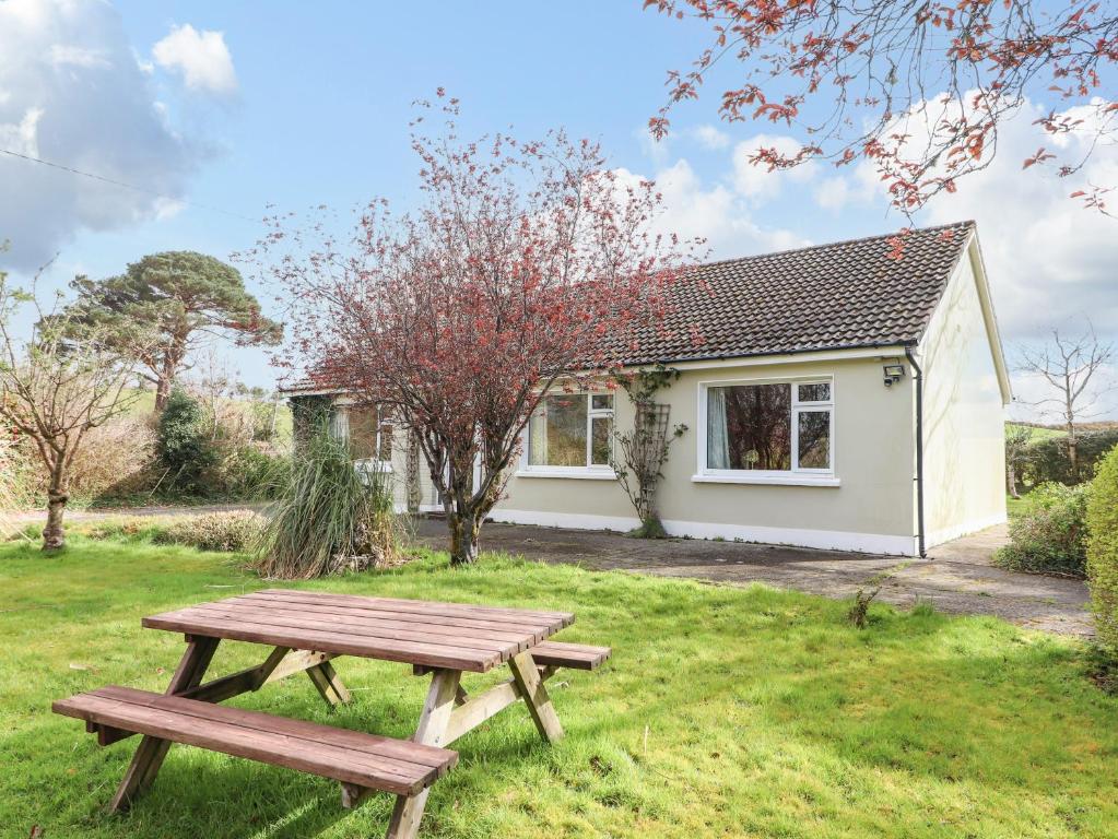 a picnic table in front of a cottage at Rowantree in Killarney