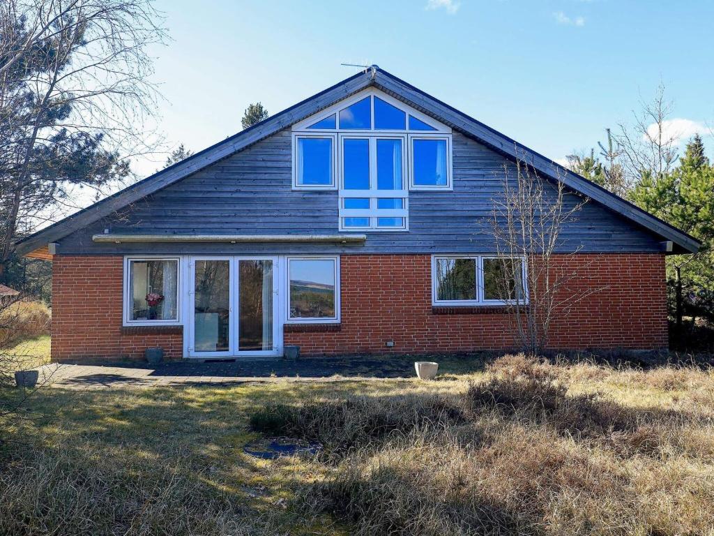 a red brick house with blue windows at 8 person holiday home in Thyholm in Thyholm