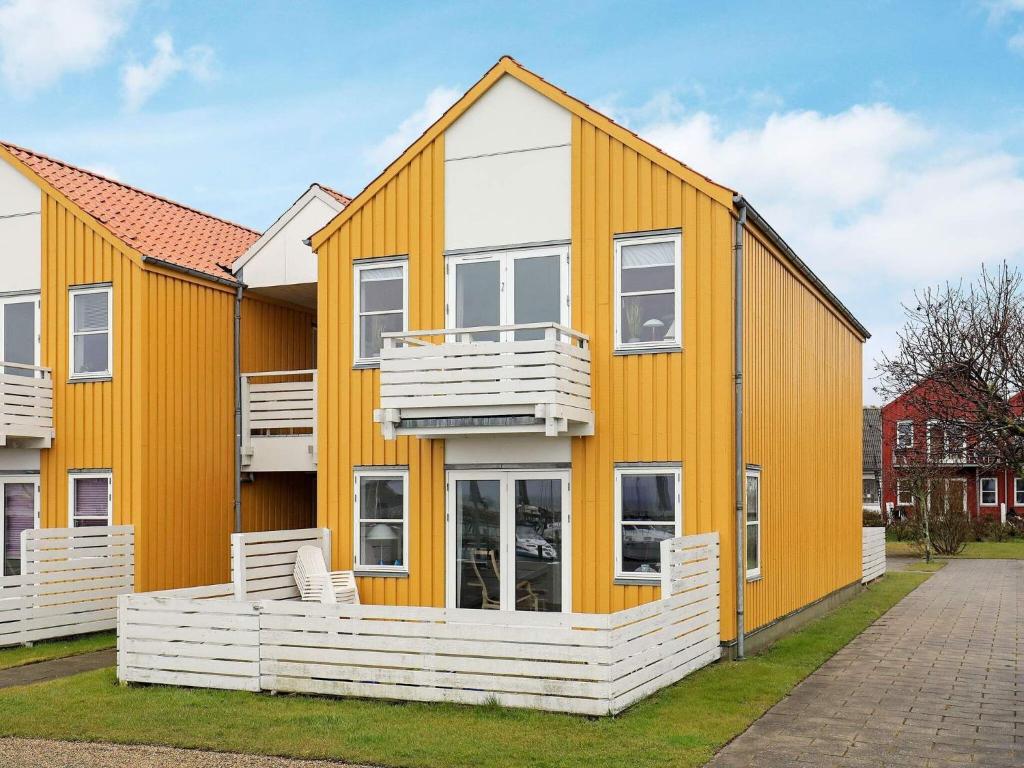 una casa con un exterior de color naranja y blanco en Holiday home Rudkøbing XVII, en Rudkøbing