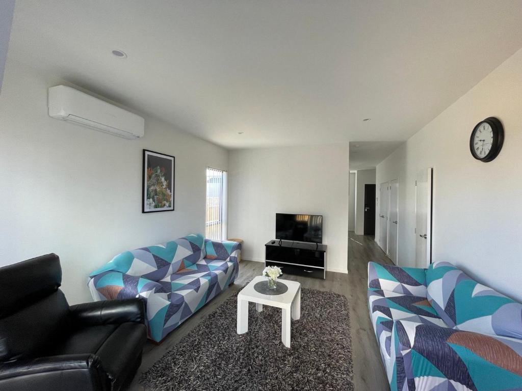 a living room with a couch and a table at 4 bedroom home fully furnished in Papakura, Auckland in Auckland