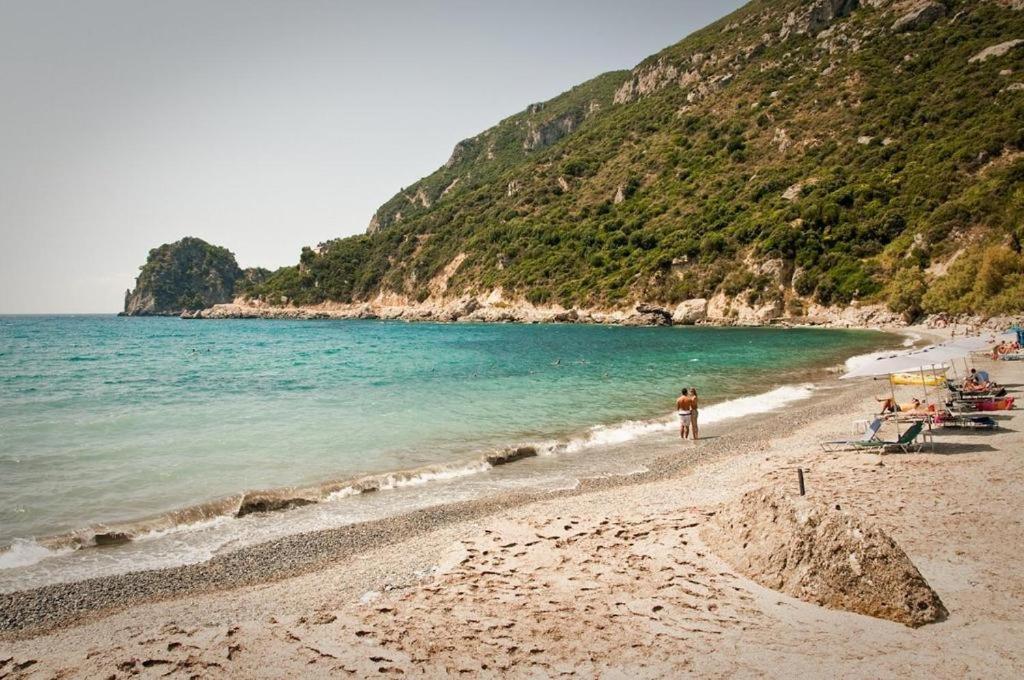 a man standing on a beach next to the ocean at Vatos Studio in Vátos