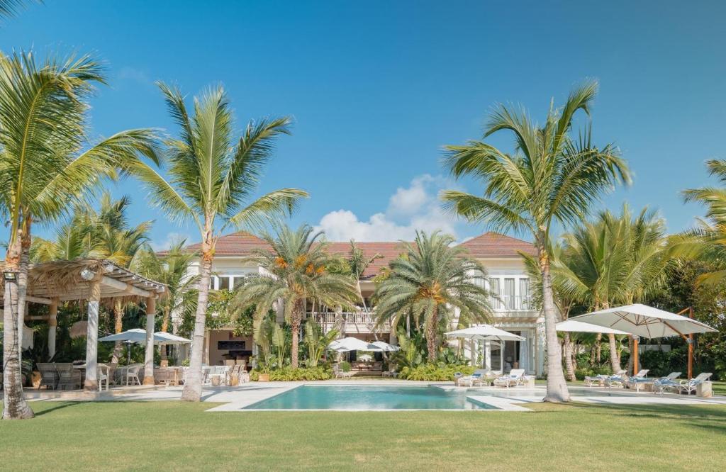 ein Resort mit einem Pool und Palmen in der Unterkunft Luxurious fully-staffed villa with amazing view in exclusive golf & beach resort in Punta Cana