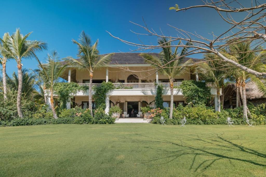 una gran casa con palmeras y un patio en One-of-a-kind villa with open spaces and amazing views in luxury beach resort, en Punta Cana