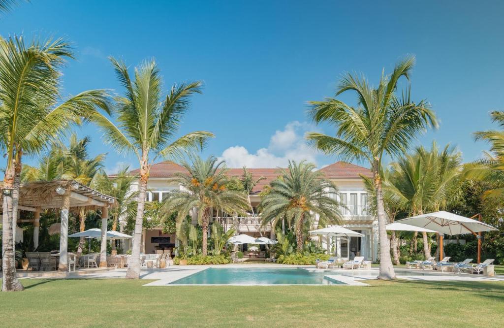 um resort com piscina e palmeiras em Unique lake-front 10-bedroom mansion in most luxurious resort of the caribbean em Punta Cana