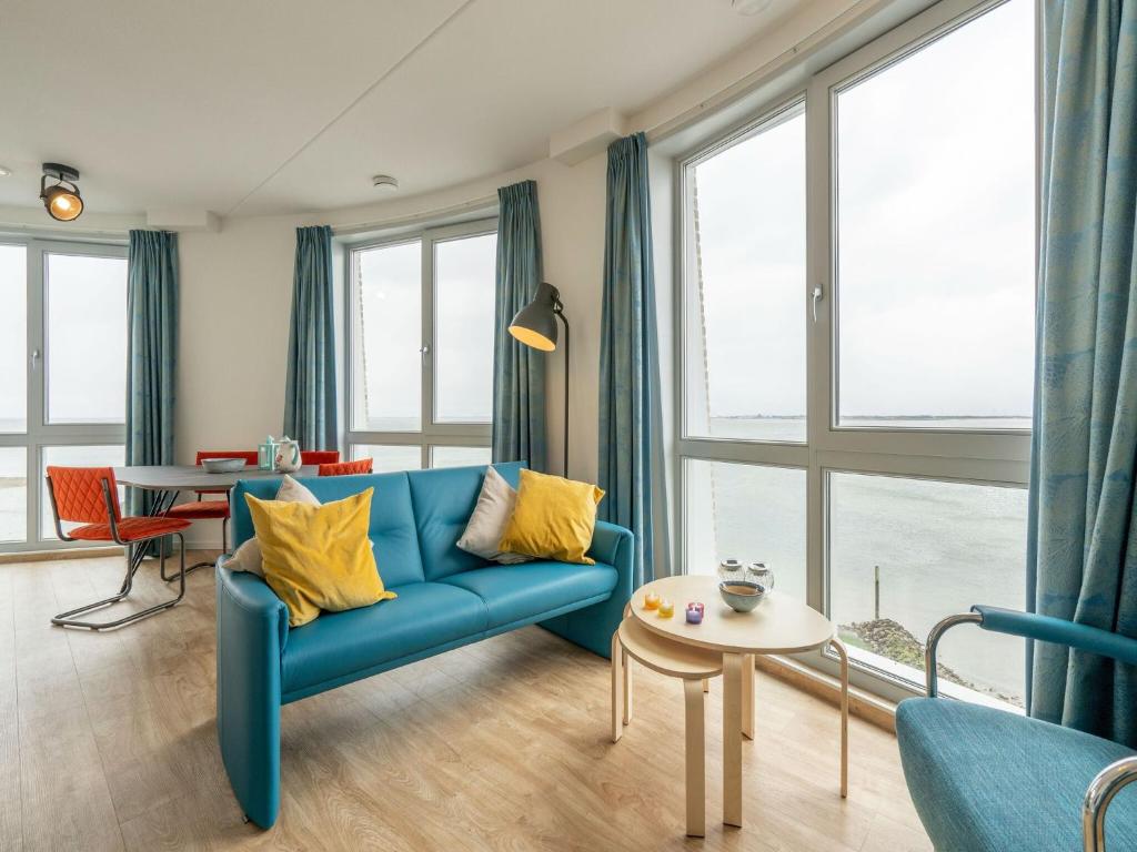 sala de estar con sofá azul y mesa en Sea view apartment in Scherpenisse with terrace, en Scherpenisse