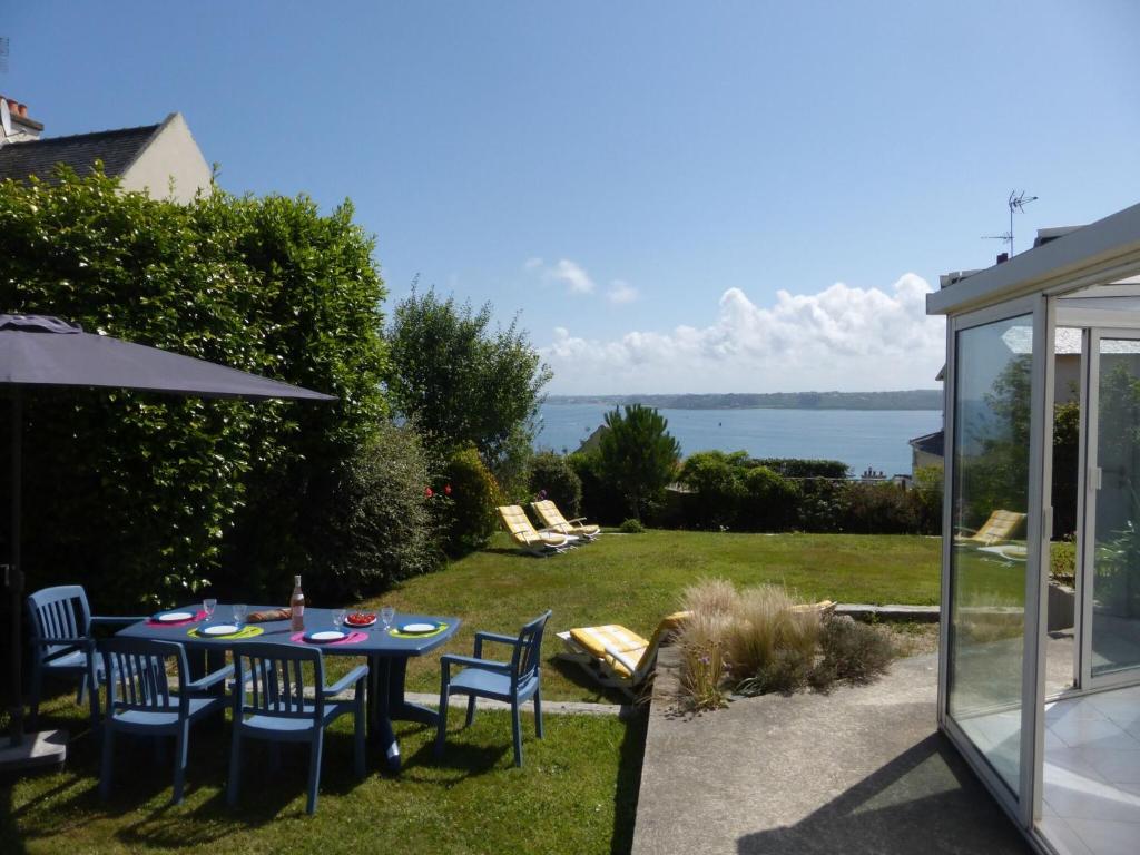 - une table avec des chaises et un parasol dans la cour dans l'établissement holiday home, Perros-Guirec, à Perros-Guirec