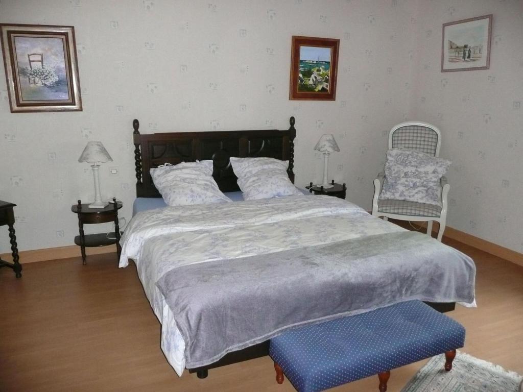 a bedroom with a large bed and two chairs at Granite stone house with fireplace, Plouguerneau in Plouguerneau