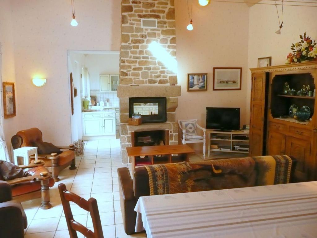 a living room with a couch and a fireplace at Granite stone house with fireplace, Plouguerneau in Plouguerneau