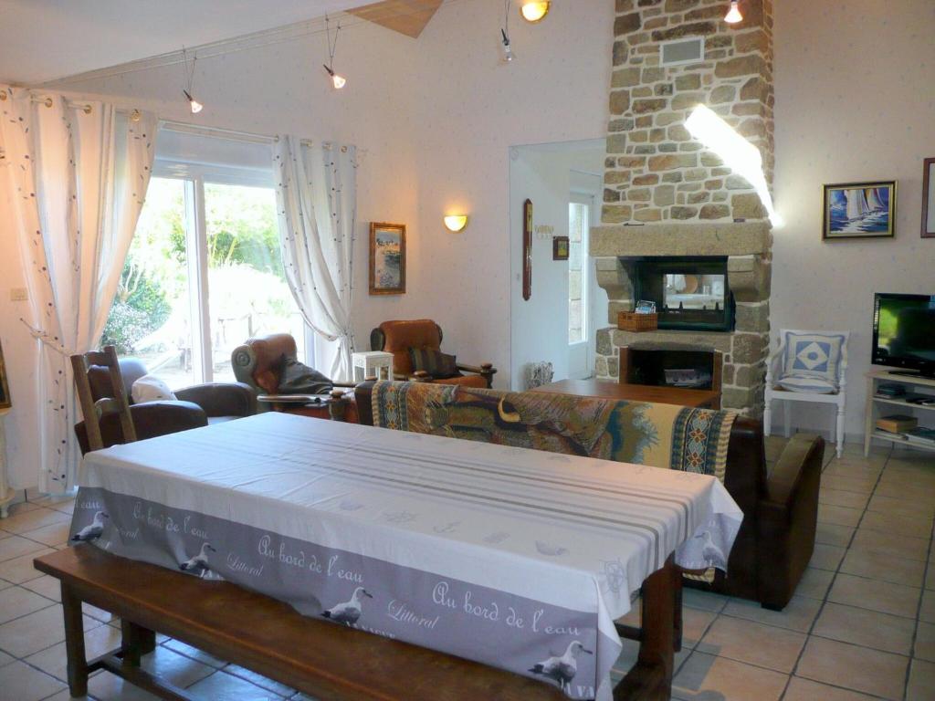 a living room with a table and a fireplace at Granite stone house with fireplace, Plouguerneau in Plouguerneau