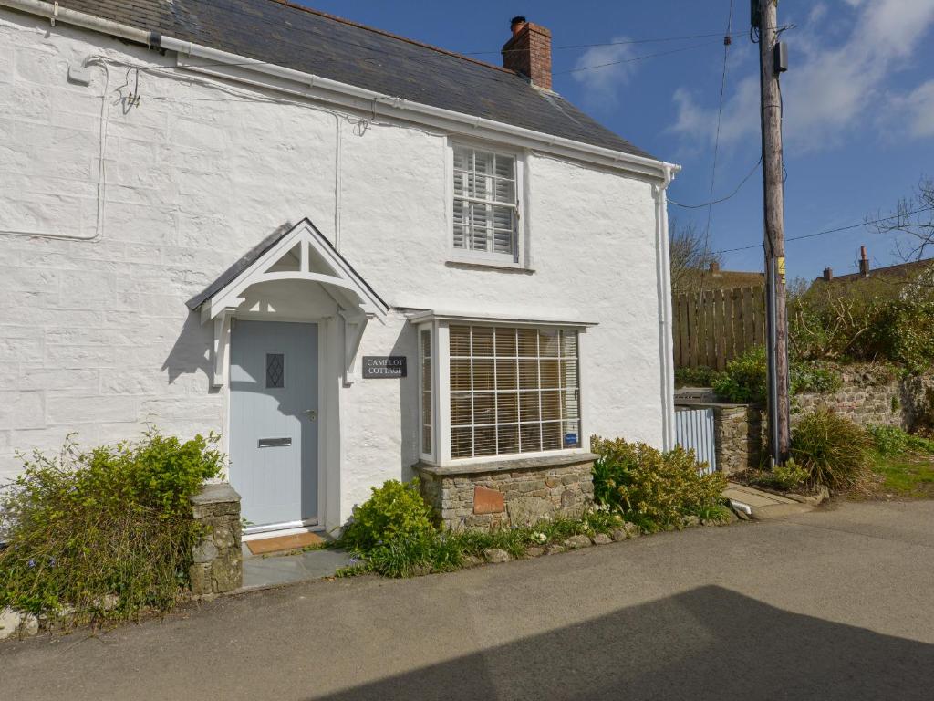 a white house with a white door and window at Camelot Cottage in Port Isaac