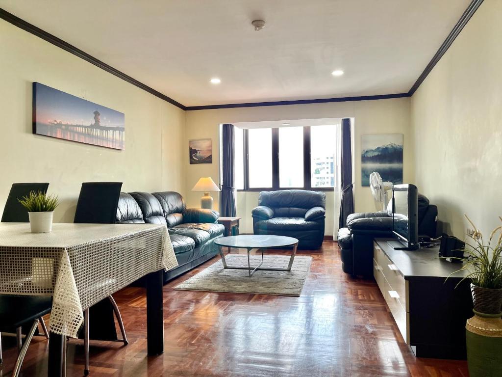 Omni Towers - Large 1 Bedroom Condo Soi Nana في بانكوك: غرفة معيشة مع أريكة وطاولة