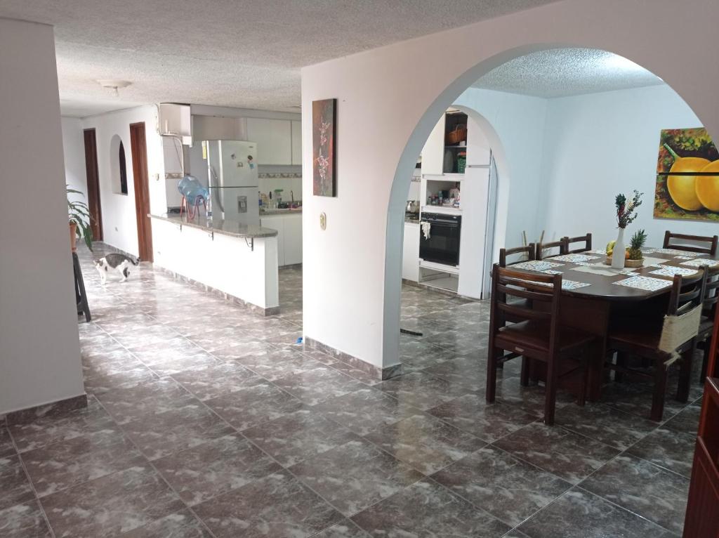 a dining room and kitchen with a table and a cat at Casa Hotel S&E in Ibagué