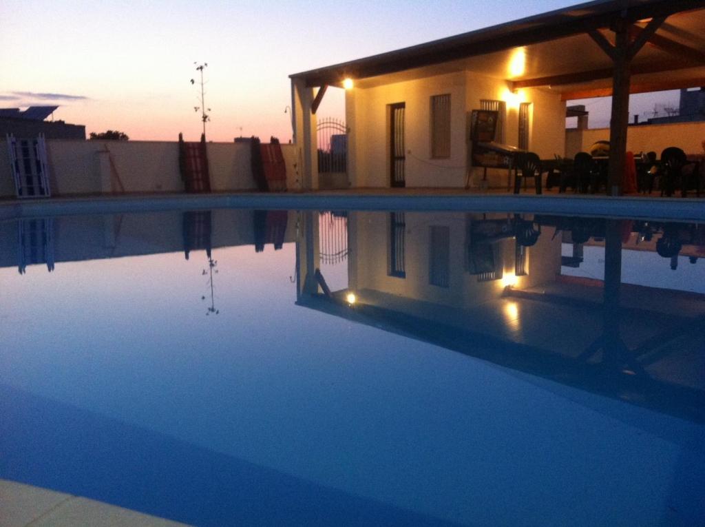 een villa met een zwembad bij zonsondergang bij B&B Terra Serena in Santa Cesarea Terme
