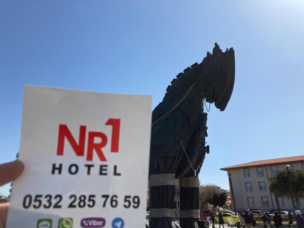 un cartel que lee "nir hotel" con una estatua de un caballo en NR1 HOTEL en Çanakkale