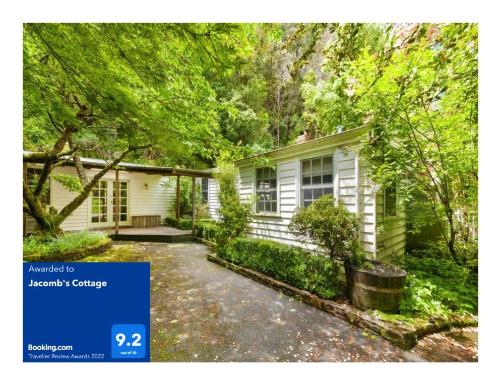 a house with a sign that reads backyard and cottage at Jacomb's Cottage and Studio in Walhalla