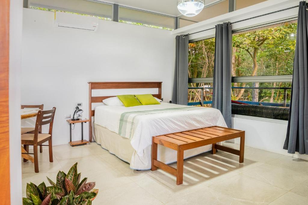 a bedroom with a bed and a table and a window at Agutipaca Bungalows in Bagaces