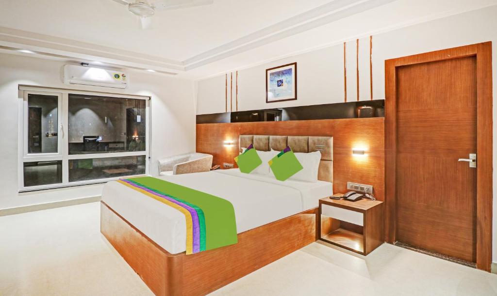 a bedroom with a large bed and a window at Treebo Trend Emora Grand in Yelahanka