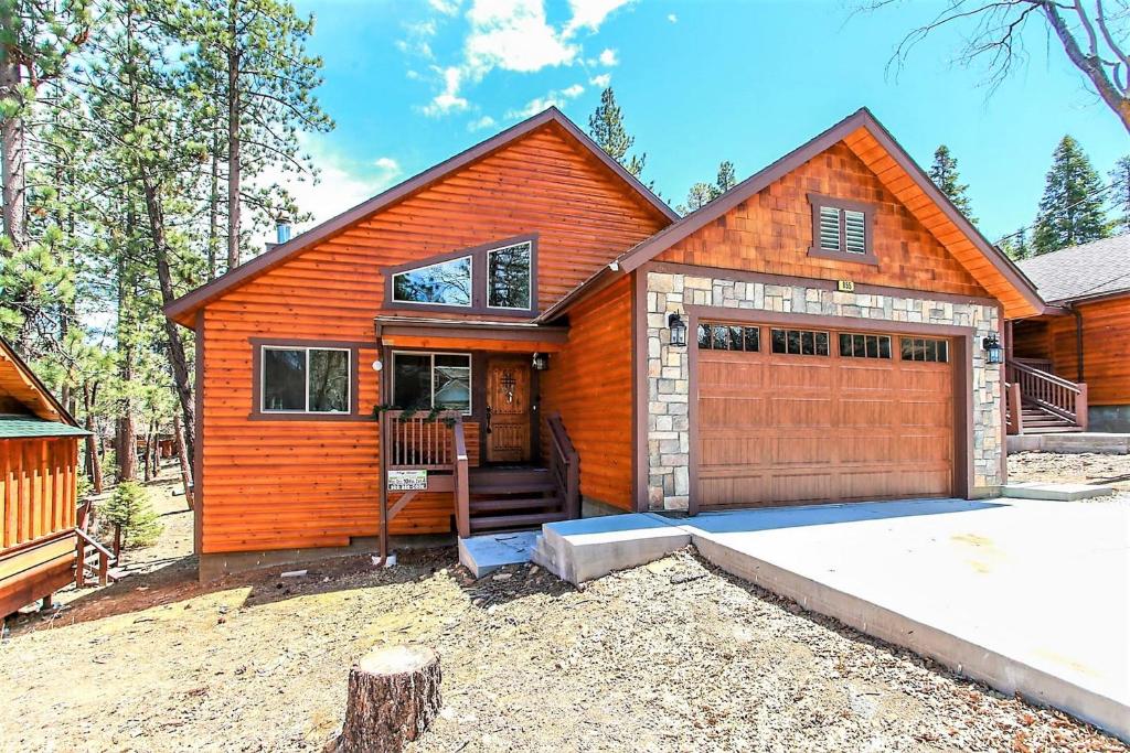 een houten huis met een garage ervoor bij Alpine Chalet-1840 by Big Bear Vacations in Big Bear Lake