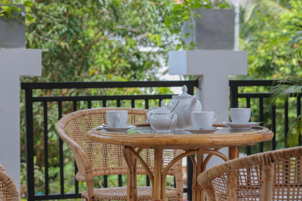 L&D Stay Inn في هيكادوا: طاولة خشبية عليها طقم شاي