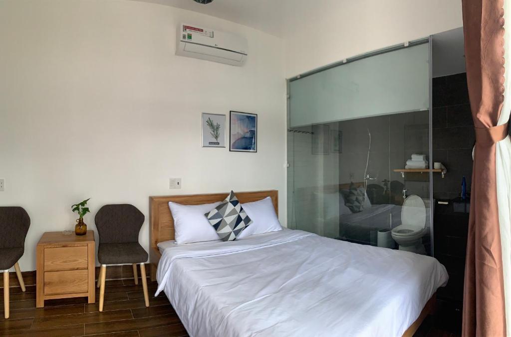 a bedroom with a bed with a glass wall at K73 De HOUSE in Da Nang