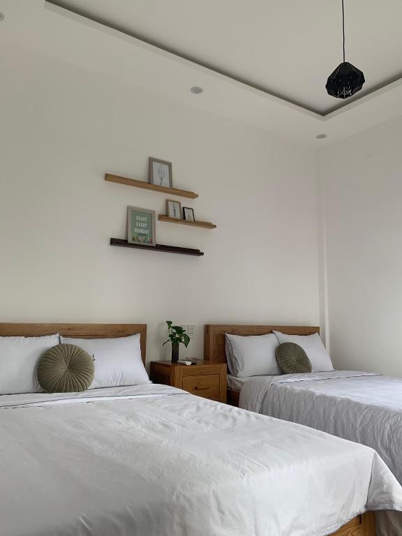 two beds in a room with white walls at K73 De HOUSE in Danang