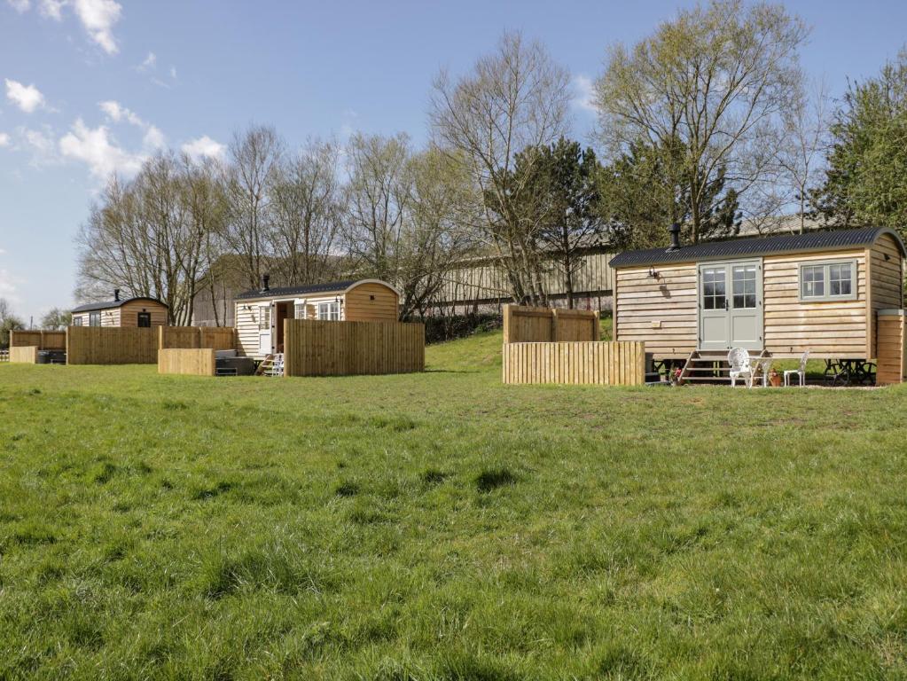 um grande campo relvado com uma caravana ao fundo em Jasmine Hut, Myrtle Farm em Bristol