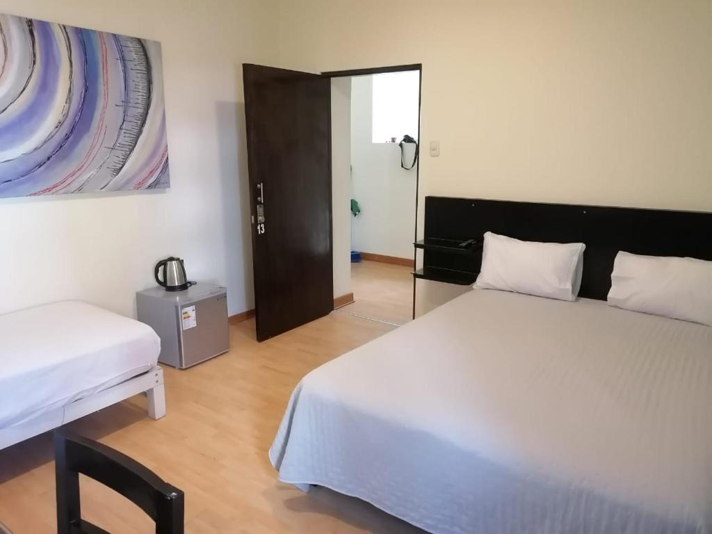 - une chambre avec 2 lits et une porte menant à une pièce dans l'établissement Miraflores Rooms, à Lima