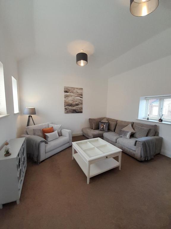 The Stables a Contractor Family 2 bed Town House in Central Melton Mowbray في ميلتون موبراي: غرفة معيشة مع كنبتين وطاولة قهوة