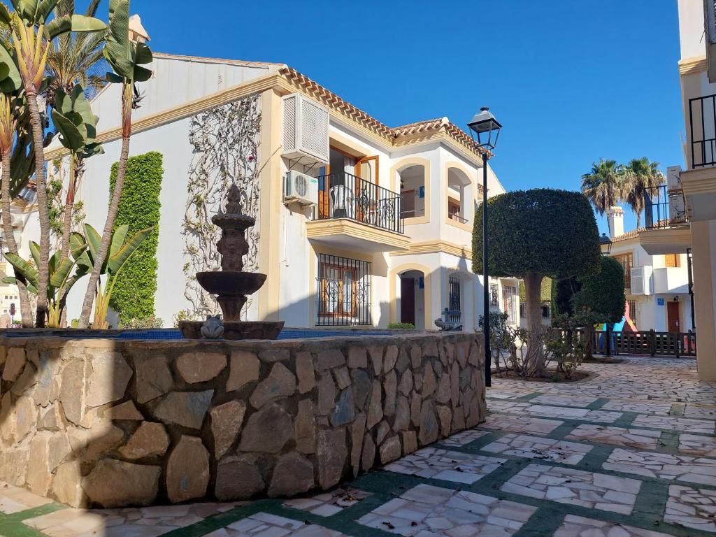 ein Gebäude mit einem Brunnen vor einer Steinmauer in der Unterkunft Casa Elena Vera in Playas de Vera