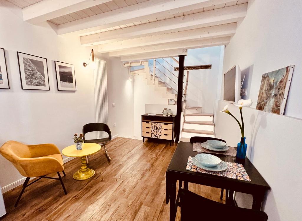 a living room with a table and chairs and a staircase at CIVICO475 House Chioggia in Chioggia