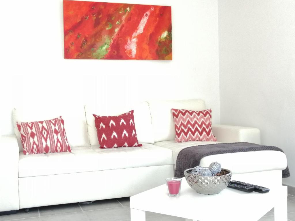 a living room with a white couch and a table at C´AN PICAFORT NEAR THE SEA in Can Picafort