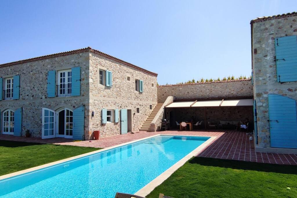 een villa met een zwembad voor een gebouw bij Magnificent Stone House Villa 14 beds 7 en-suite rooms Çeşme (450 m2 6500 land) in Çeşme