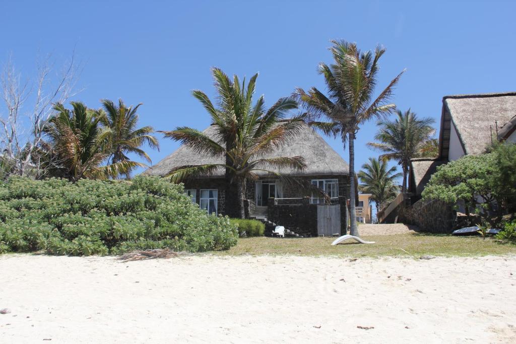 a house on the beach with palm trees at Keravel Bungalows in Pointe d'Esny