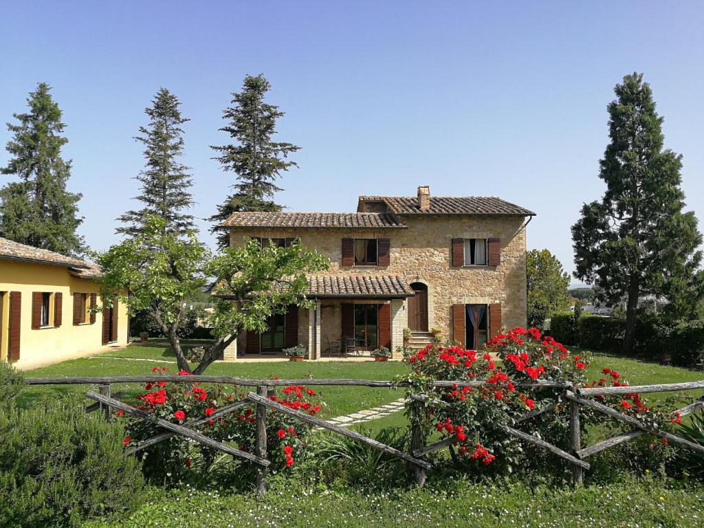 una casa con flores rojas delante de ella en Agriturismo Residenza il Girasole, en Bettona