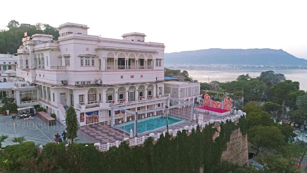 un gran edificio blanco con una piscina frente a él en Hotel Merwara Estate- A Luxury Heritage Resort, en Ajmer