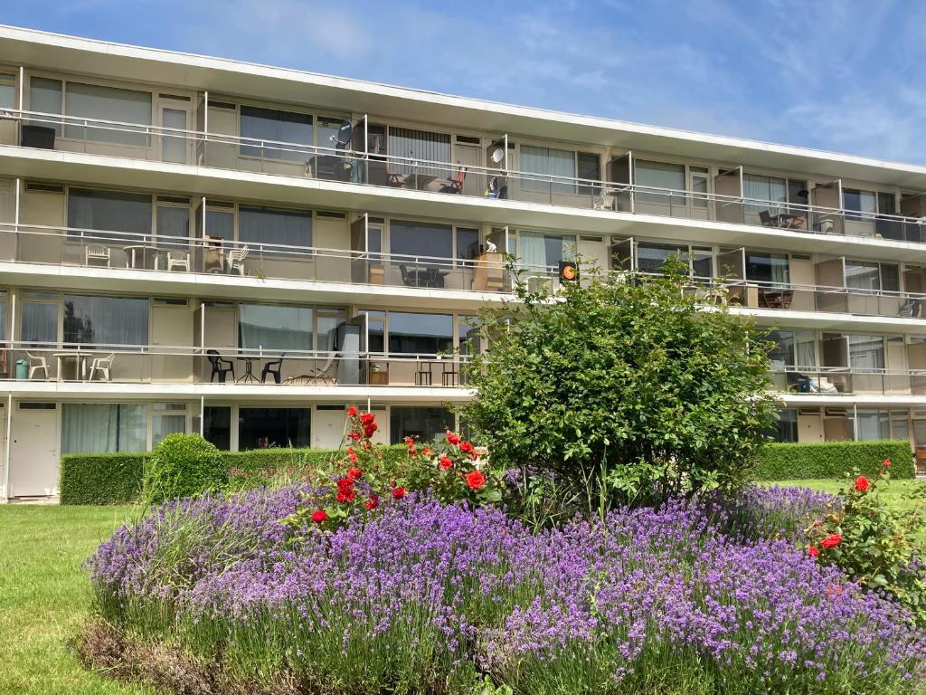 een appartementencomplex met bloemen ervoor bij Bel Acacia in De Haan