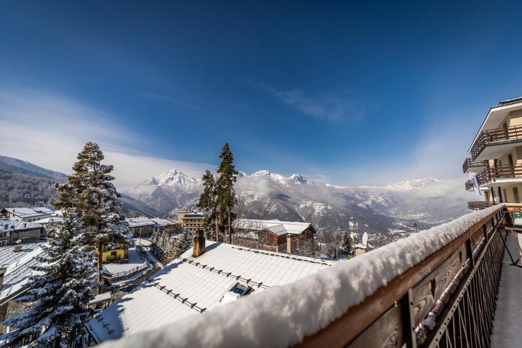 a view of a snowy mountain from a balcony at Hotel Gran Baita in Sauze dʼOulx